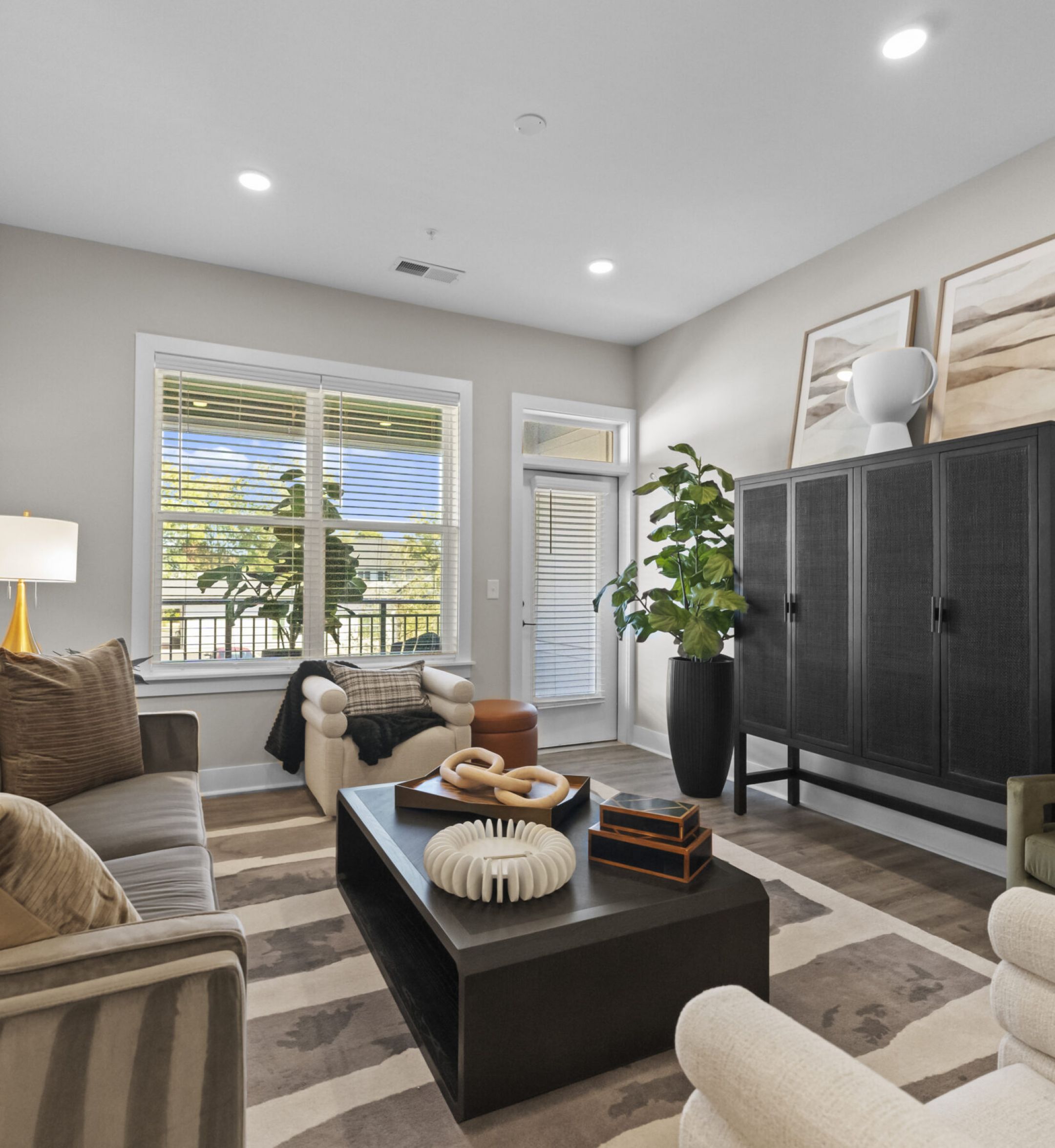 The Sloan at LoSo apartments in Charlotte, NC kitchen with white floor-to-ceiling cabinets, stainless steel appliances, and lots of natural light