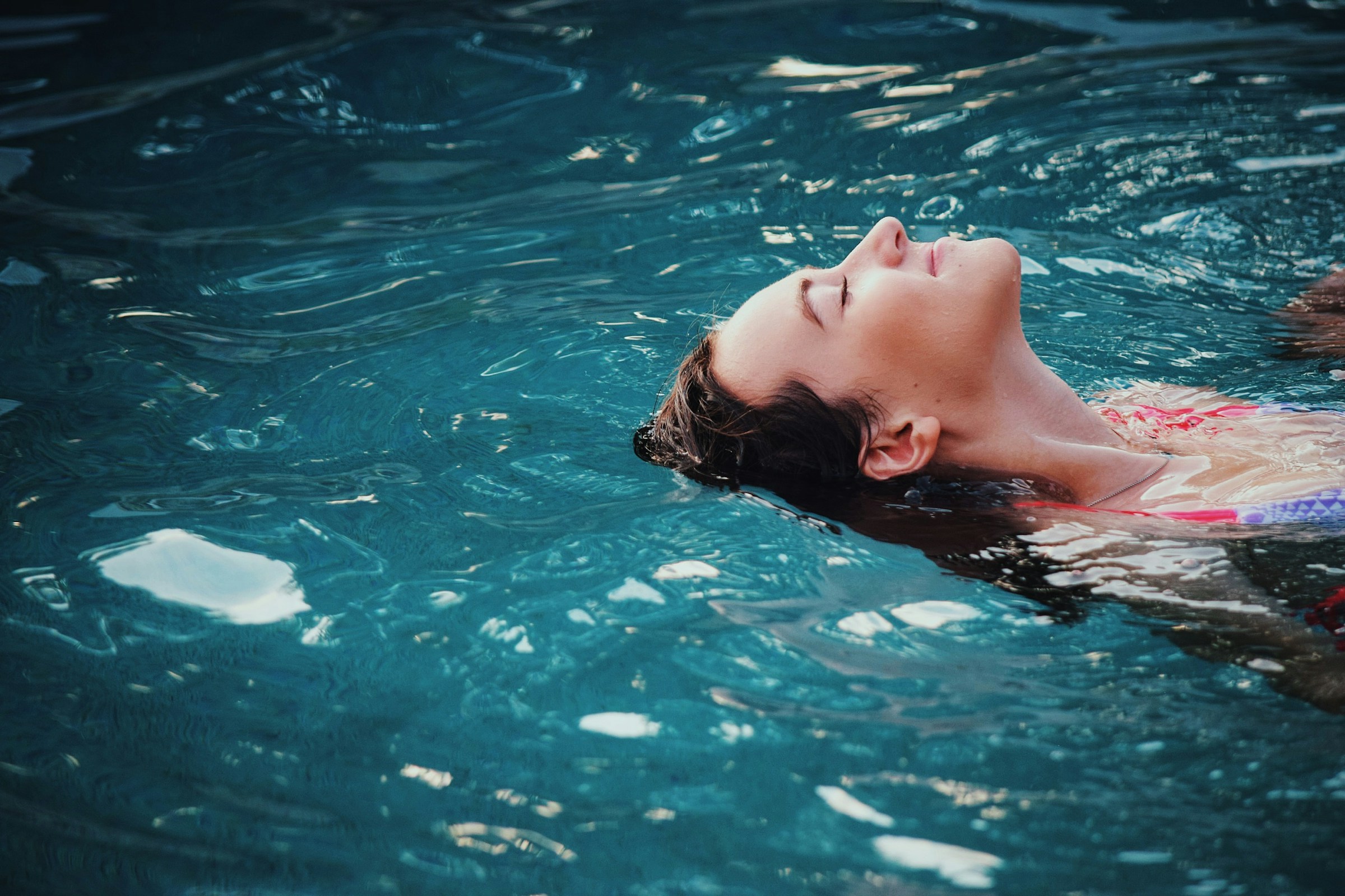 The Sloan at LoSo apartments in Charlotte, NC woman swimming on her back in a refreshing pool