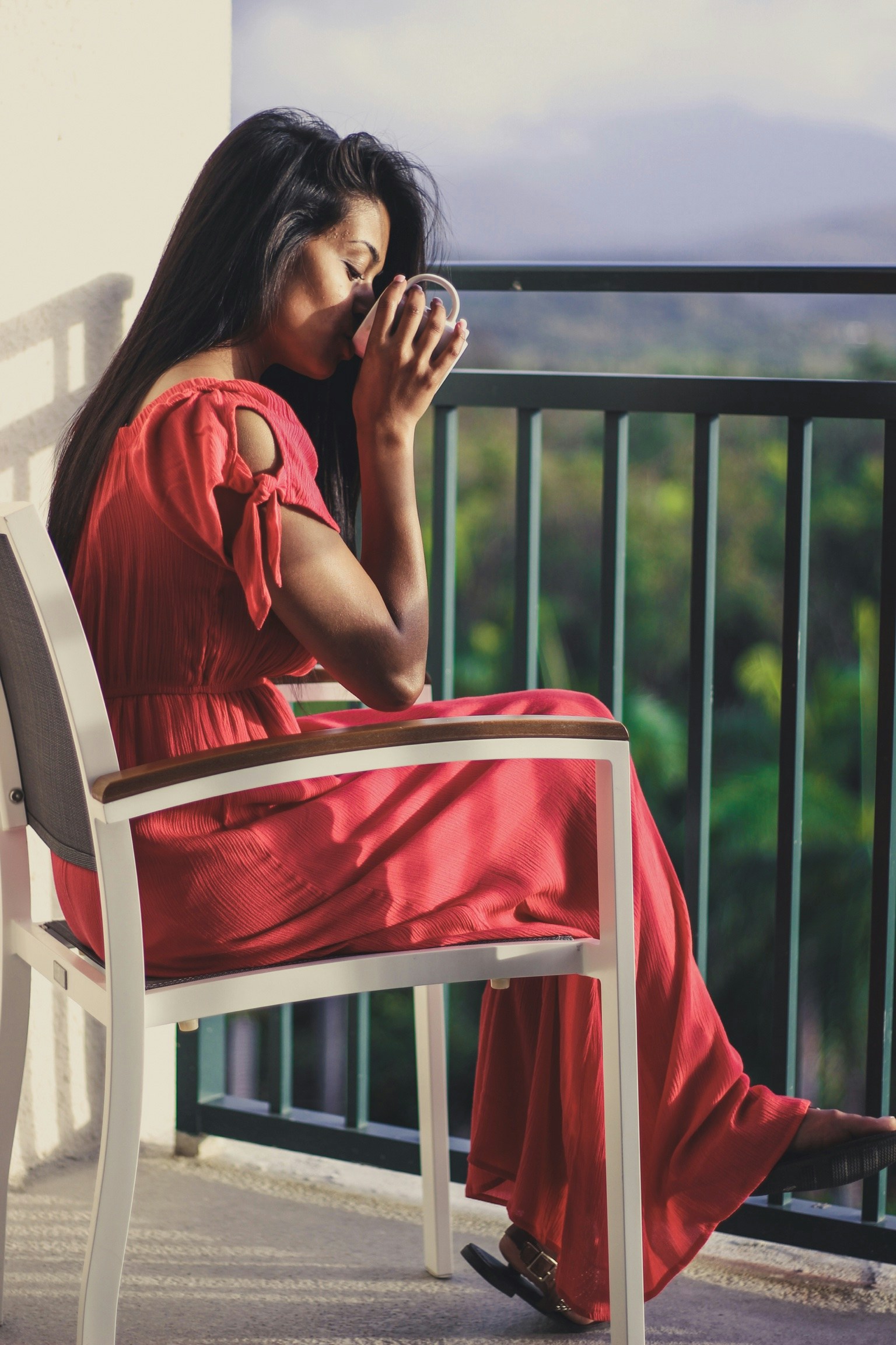 The Sloan at LoSo in Charlotte, NC apartment features with oversized balconies and woman drinking coffee on her balcony